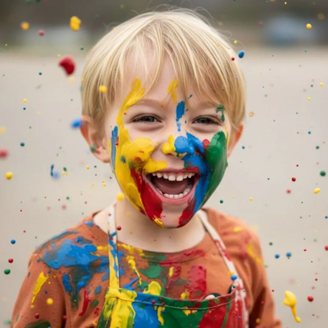 Niño sonriendo con pintura de colores en la cara